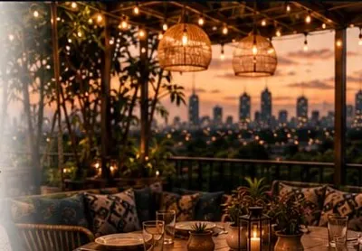 The terrace at dusk with lanterns and city lights beyond