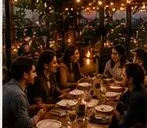 A long table of friends under string lights